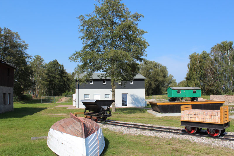 zeigt Ansicht von Außenbereich mit altem Fischerkahn und Ziegellore