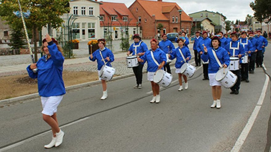 zeigt Fanfarenzug an der Spitze des Festumzugs auf der Straße