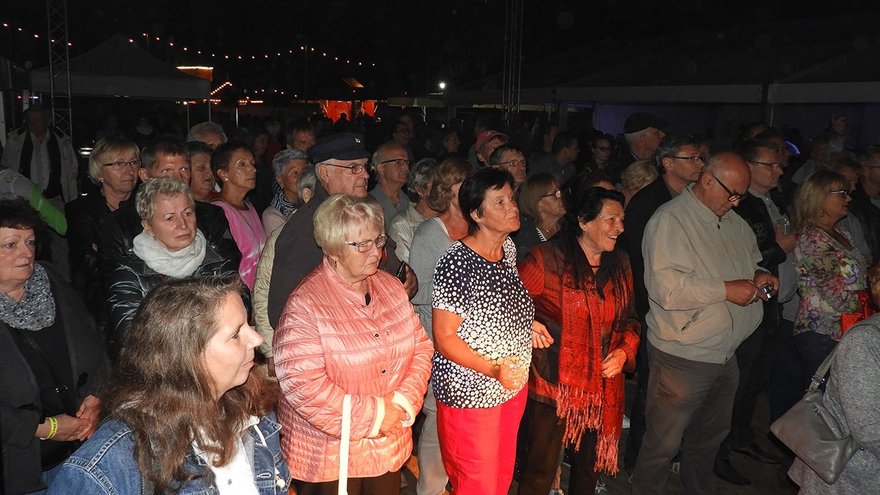 zeigt stehende Zuhörer beim abendlichen Konzert