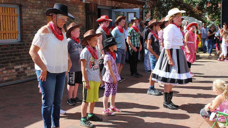 zeigt Personengruppe im Westernlook beim Auftritt