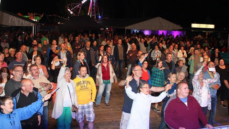 öffnet internen Link in aktuellem Fenster zeigt zuschauende Festbesucher am Abend