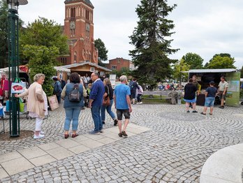zeigt Marktstände und Besucher