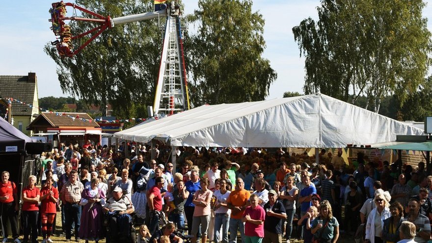 zeigt Schaustellergeschäfte und Besucher auf dem Festplatz