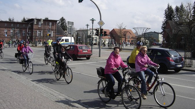 zeigt Radfahrer und Autos auf einer Straße