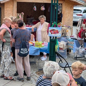 zeigt Marktstand und Personen davor