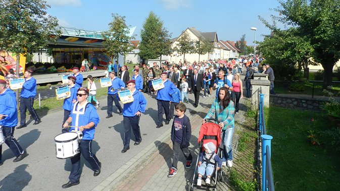 zeigt Blick auf den Festumzug mit Fanfarenzug vorneweg