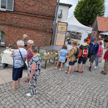 zeigt eine Personengruppe, die Marktangebote betrachtet